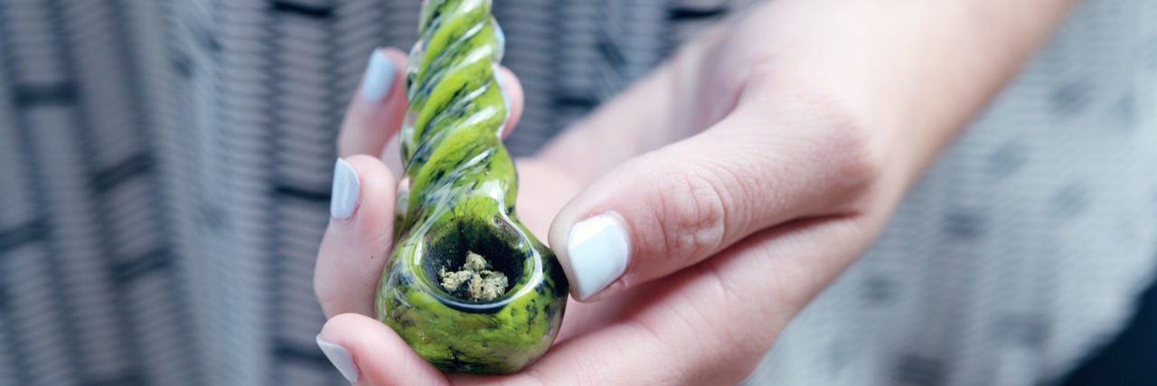 Close up of a woman holding a bong