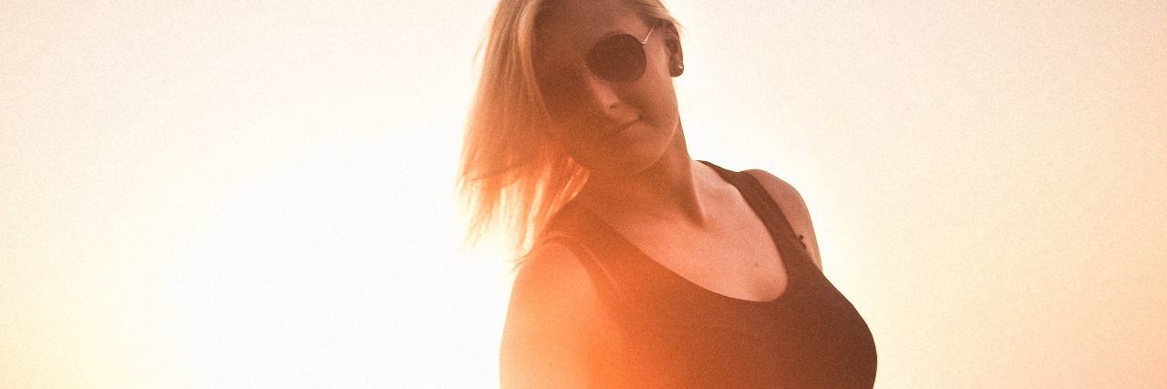 Accepting 'the Past Is the Past' in Trauma Therapy photo of woman at sunset in field looking relaxed