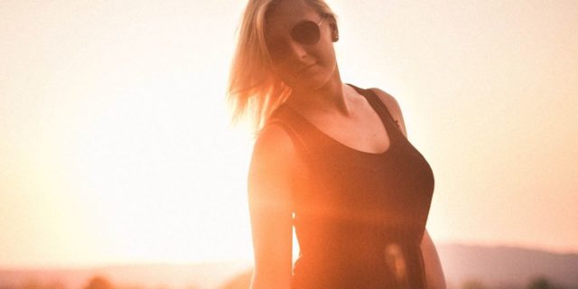 photo of woman at sunset in field looking relaxed