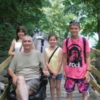 Suzanne's family on a wooden bridge. Her father is sitting in his wheelchair.