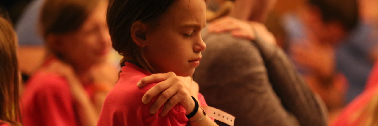 Children's Grief Awareness Day: Tips for Supporting Kids child hugging himself in a group setting