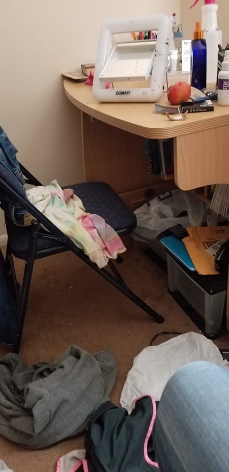 Picture of a desk and chair with clothes strewn about