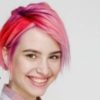 Young beautiful girl with a short hair cut pixie bob. Color hair coloring, red pink color. Shirt in a cellar, casual style. Autism and Identity-First Language