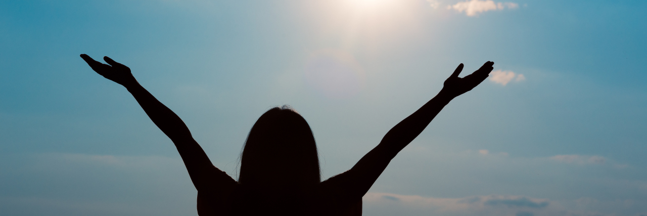Thank God for the Dads of Children With Disabilities a girl raising her arms toward the sunlight in happiness