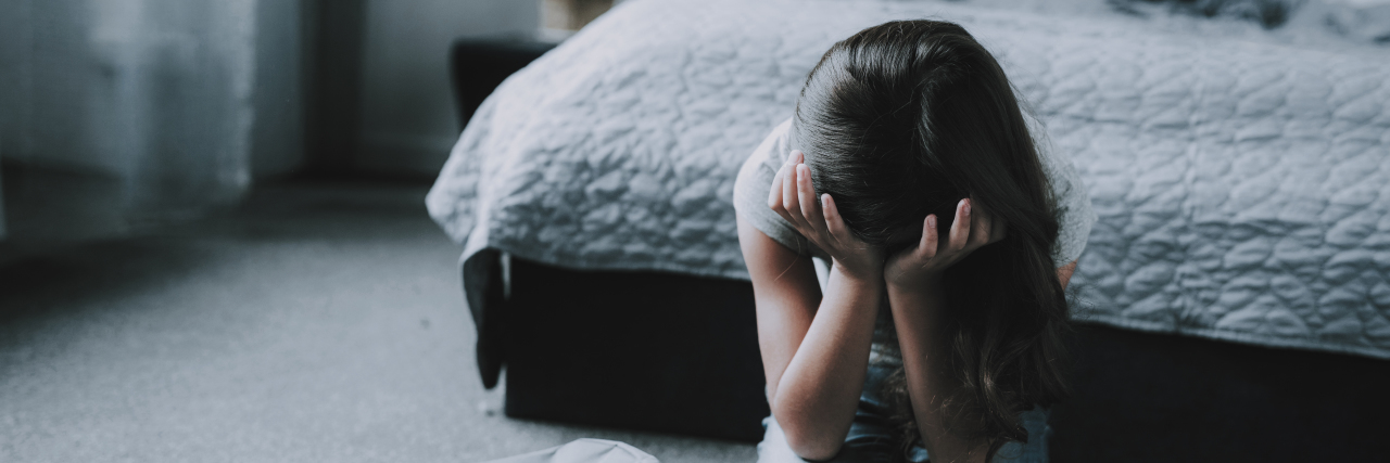 Tips for Helping Kids With Behavioral Challenges Sad girl kneeling on the floor crying.