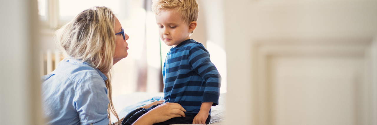 Autistic Adult Responds to Study on PTSD, Parenting Autistic Child A young mother talking to her sad toddler son inside in a bedroom.