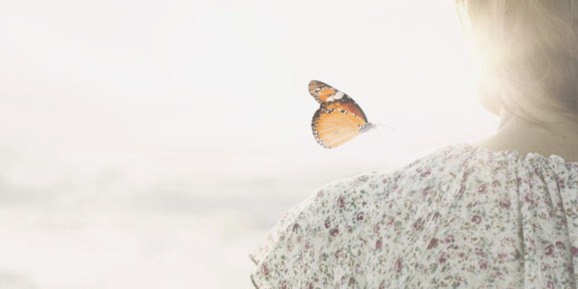 How to Cope With the Grief of Your Child’s Rare Disease Diagnosis a colorful butterfly leans delicately on the shoulders of a woman