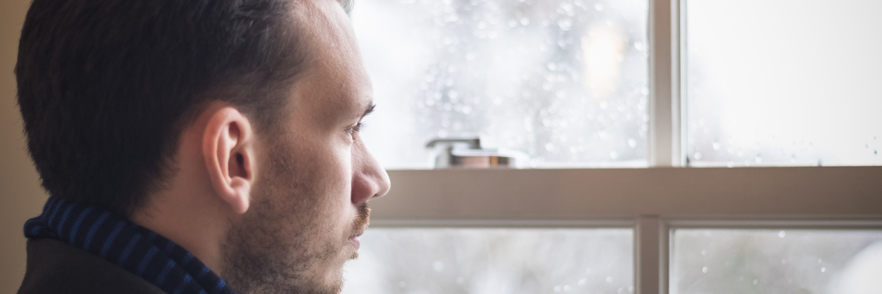 Medical Expert Explains Pain Associated With Grief and Suicide Loss Portrait of a man looking out window