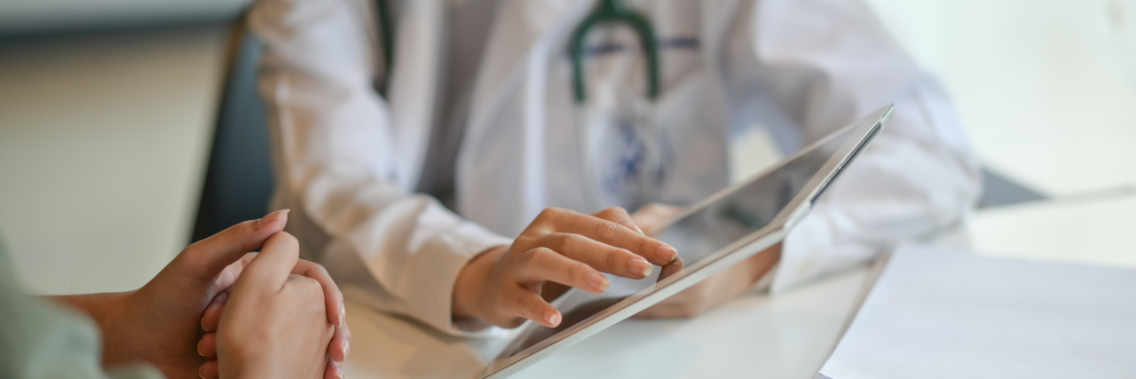 Tips for Managing Doctors’ Appointments With Chronic Illness Doctor showing a patient some information on a digital tablet.