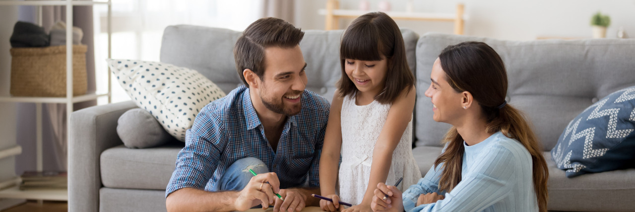5 Anxiety-Reducing Tools to Teach and Help Kids With Anxiety Mom and Dad on either side of daughter sitting and smiling with her