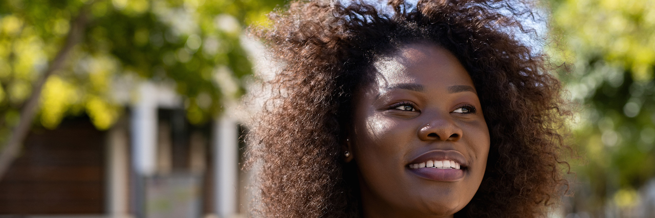 The Importance of Showing Up for Another's PTSD and Grief A woman smiling outside