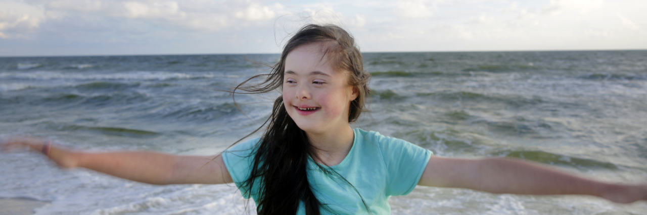 Down Syndrome Is Normal Girl with Down syndrome at the beach.