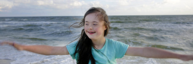 Girl with Down syndrome at the beach.