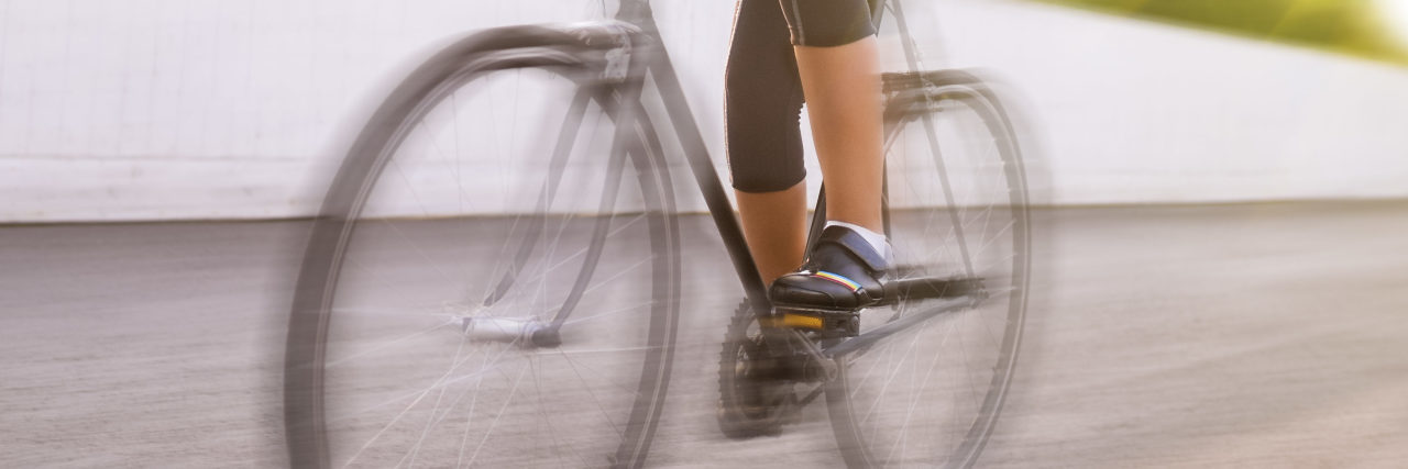 Marion Clignet, Champion Cyclist With Epilepsy Shares Her Story Female athlete racing on a bike. motion blurred image.