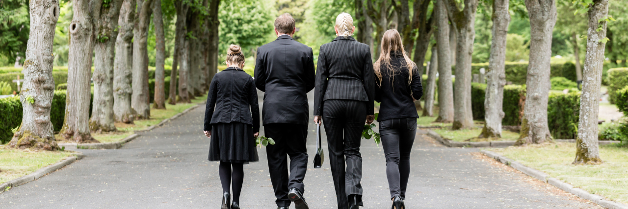 How to Support a Loved One Through the Different Forms of Grief a family walking in a graveyard