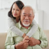 Happy smiling aged woman hugging her husband from behind