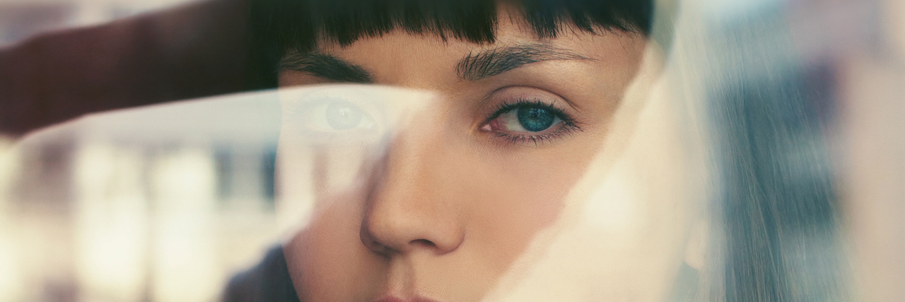 Developing Resilience Improves My Mental Health young woman looks at camera through a window