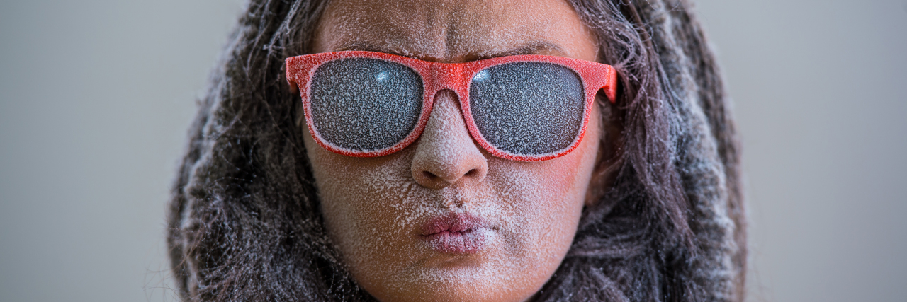 10 Tips to Help You Survive Winter With a Chronic Illness Woman with sunglasses and snow-covered face.