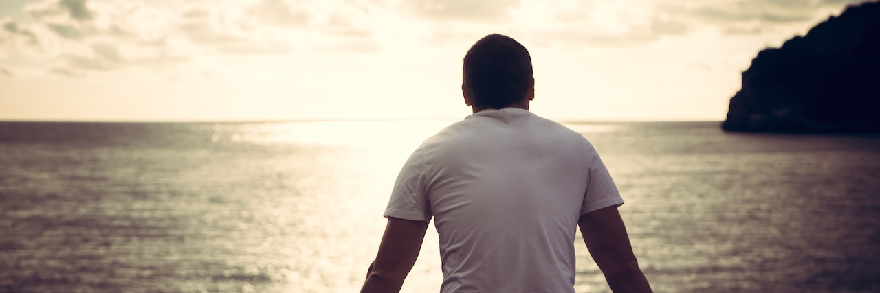 When Bipolar Disorder Makes You Isolate lonely man looking with hope at horizon with sunlight during sunset