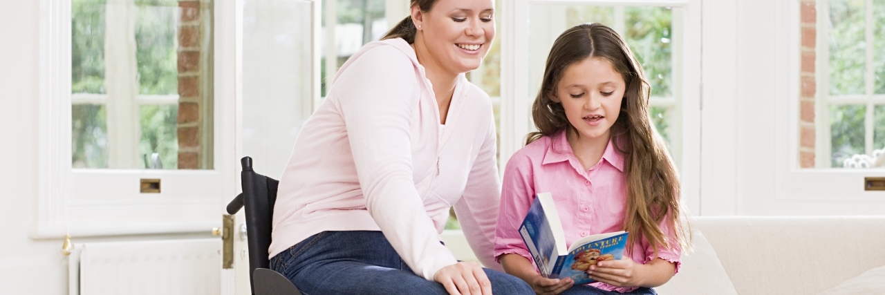 Open Letter to Disabled Parents Mother sitting in her wheelchair helping daughter read book