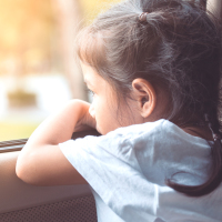 child looking sad by a window
