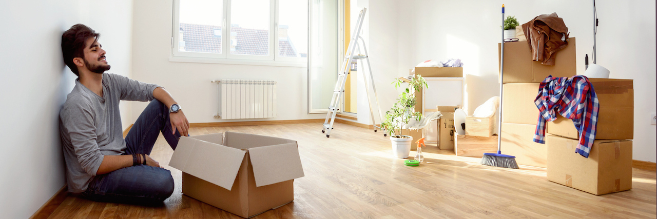 How Change Helps Me Cope With Bipolar Disorder Man just moved into new home unpacking boxes sitting on the floor