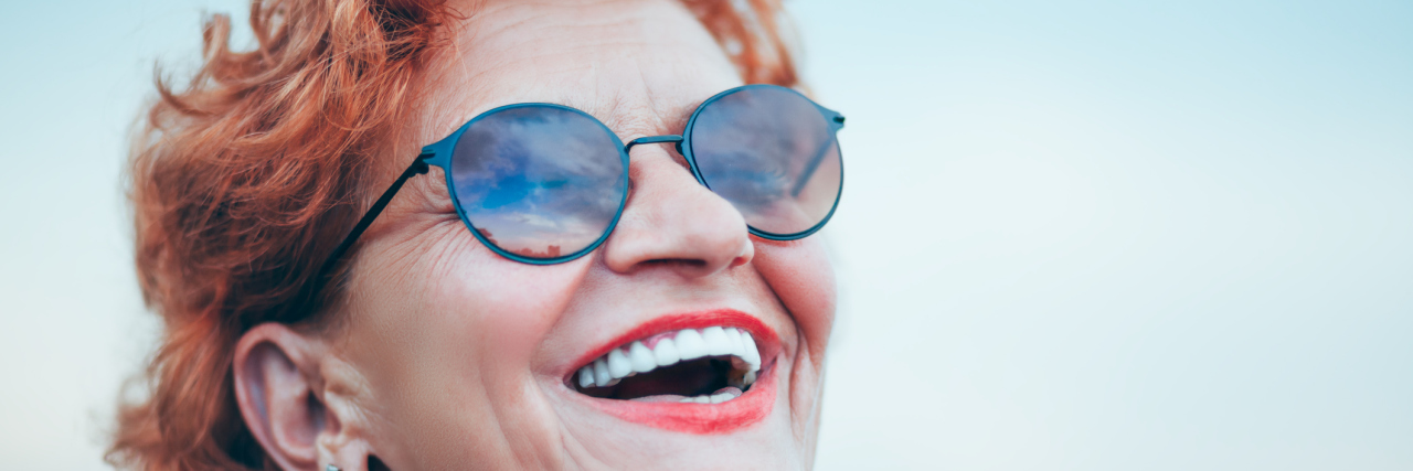 Finding Humor in Chronic Illness A woman smiles looking toward the sky.