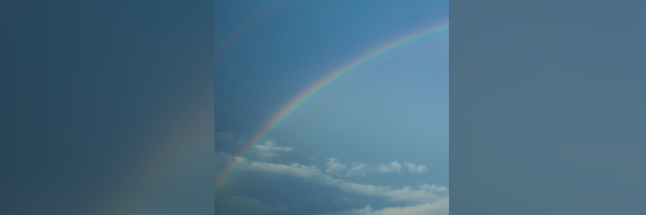 original photo by author of a blue sky with a rainbow