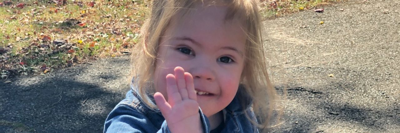 Thinking About the Future for My Child With Down Syndrome Elena's daughter who has Down syndrome waving.