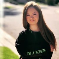 Kennedy Garcia wearing a long-sleeve black shirt with the words, "I am a personal, not a label" printed on the sleeves