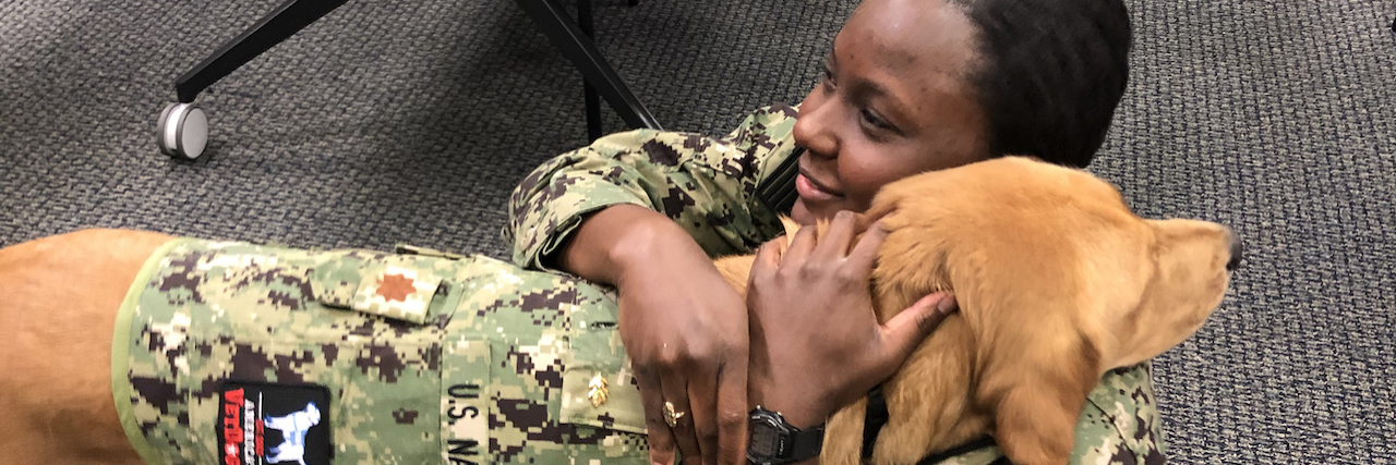 KHN: Dog Teaches Military Med Students the Merits of Service Animals Brelahn Wyatt, a second-year medical student, hugs Shetland, a half-golden retriever, half-Labrador retriever who also happens to be a lieutenant commander in the Navy and a clinical instructor in the Department of Medical and Clinical Psychology at the Uniformed Services University of the Health Sciences. (Julie Rovner/KHN)