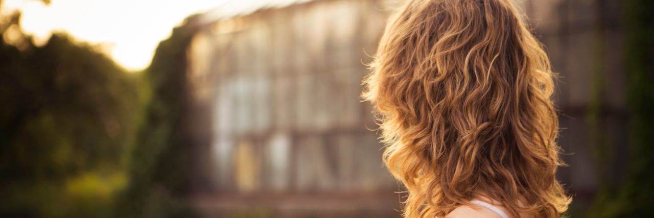 11 Things I Learned in Intensive Outpatient Treatment side view of woman looking toward a building, wavy blonde hair wearing off the shoulder white blouse