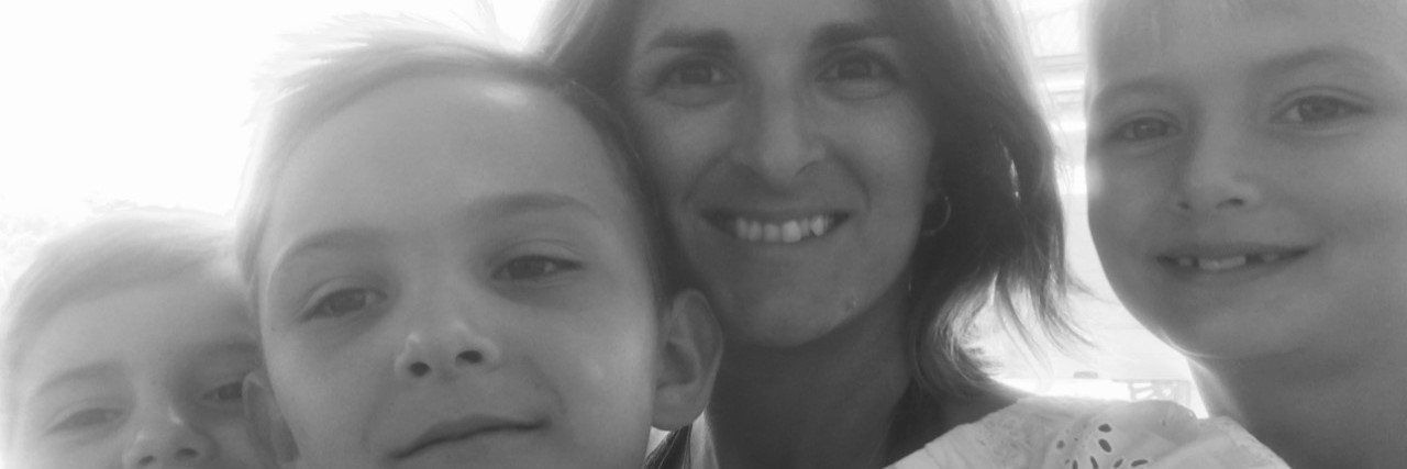 Trying to Rebuild My Confidence After Encephalitis Black and white image of mother with her three sons looking at the camera