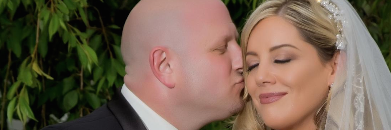 The Important Role My Husband Plays as My Grief Partner a husband kissing his bride on the cheek