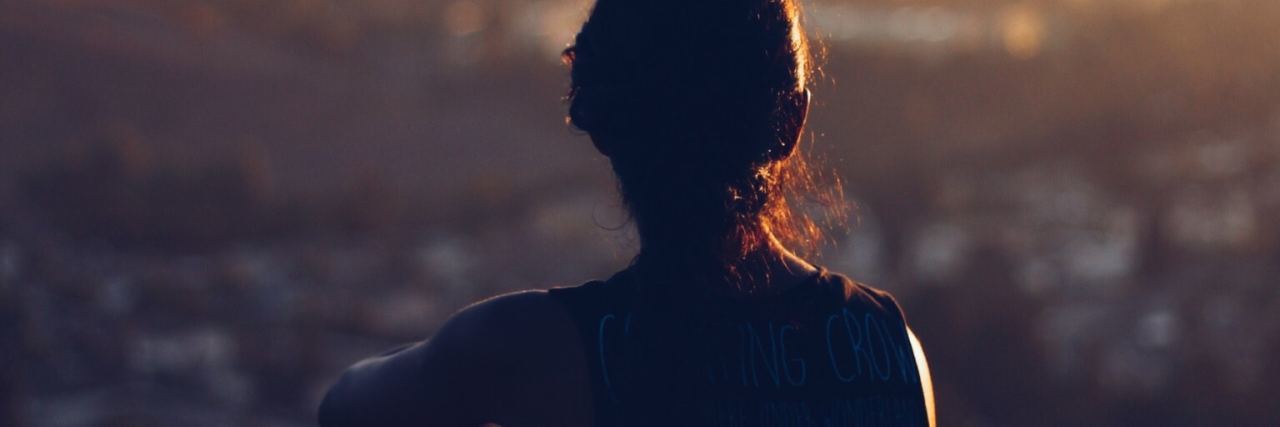 What to Know If You’re Confused About Mental Health Insurance photo of young woman silhouette overlooking city