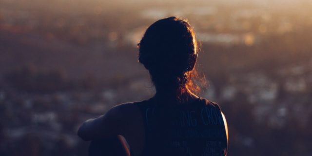photo of young woman silhouette overlooking city