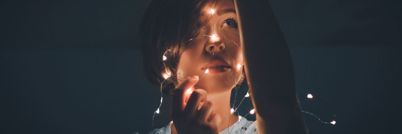 Why Everyone Should Try Therapy photo of woman holding fairy lights around her head