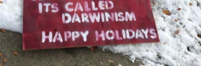 Red and white sign that reads: "Stop asking for money. Let the baby die. It's called Darwinism. Happy Holidays"