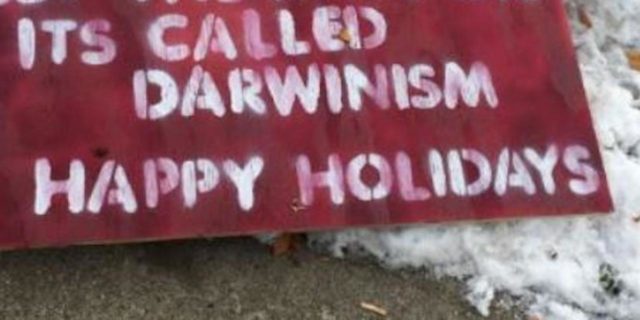 Red and white sign that reads: "Stop asking for money. Let the baby die. It's called Darwinism. Happy Holidays"
