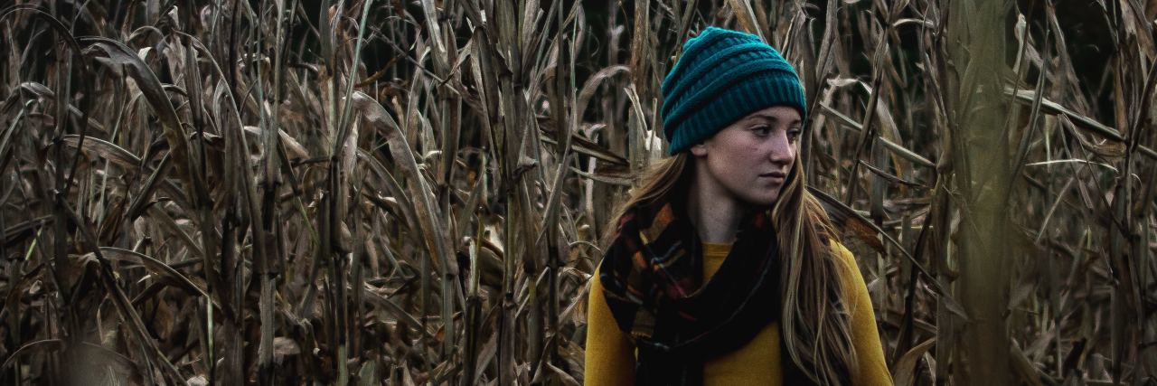 When High-Functioning Depression Hides How Much You're Struggling photo of young woman in crops alone and looking behind her
