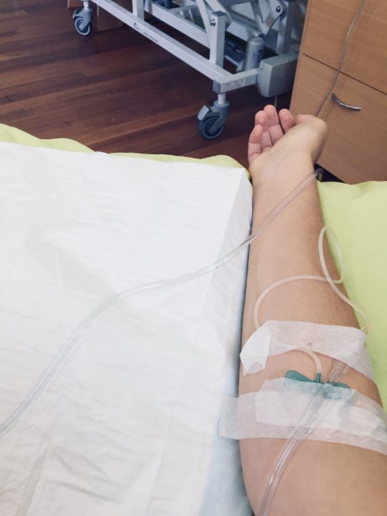 a woman's arm in a hospital bed with a needle