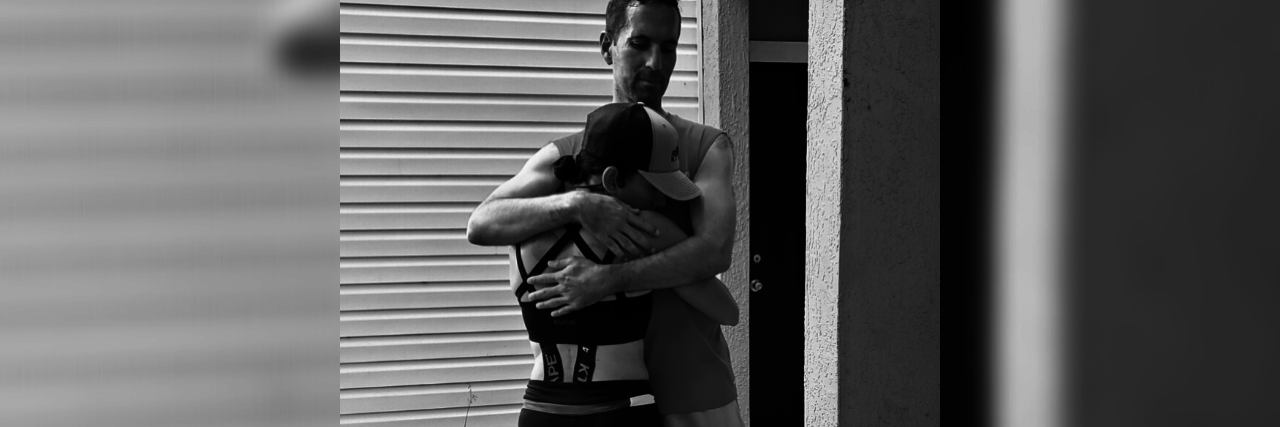 Running Marathons With Chronic Illness Gelcys embracing her husband while wearing her running attire.