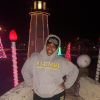 Jae posing outside with Christmas lights.