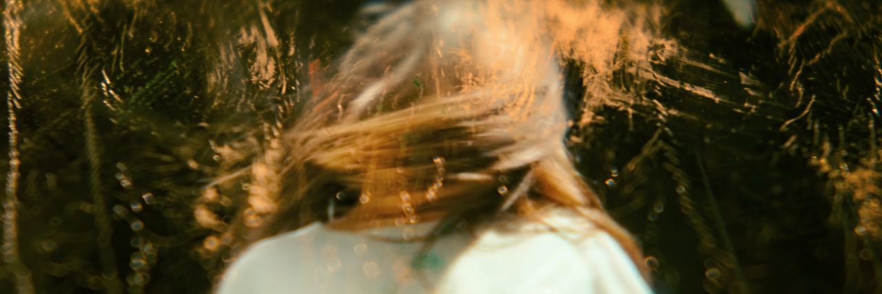 Why You Shouldn't Suddenly Stop Taking an Antidepressant distorted photo of young woman with hair hiding her face