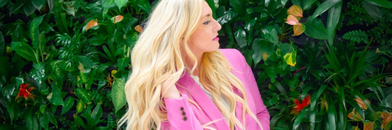 How to Explain Chronic Pain and Illness to Family Over the Holidays photo of blonde woman standing in front of greenery with eyes closed