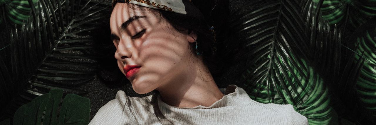Why Better Sleep Is Important for Mental and Physical Health photo of woman lying in leaves with eyes closed as if she is sleeping