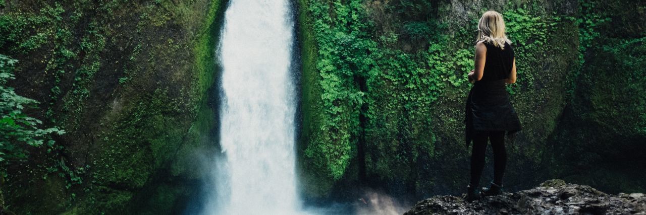 When Suicidal Thoughts Interrupted My Mindfulness Visualization photo of young woman standing on rock by river and overlooking waterfall