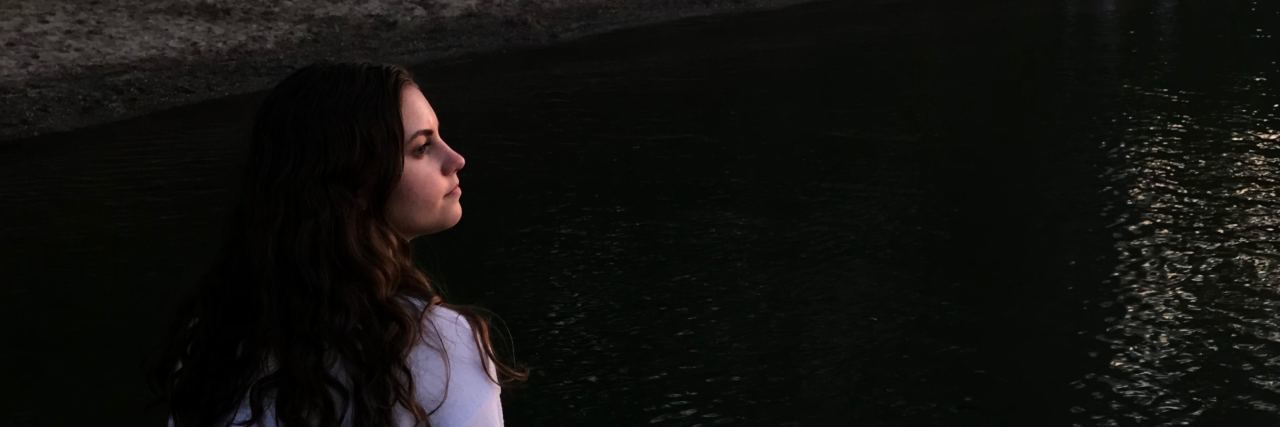 How Dialectical Behavior Therapy Helped Me Survive a Breakup photo of young woman sitting by water at sunset looking out