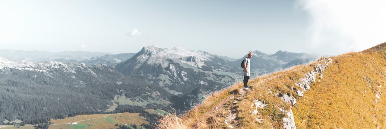 Man hiking on a mountain on a cloudy day.