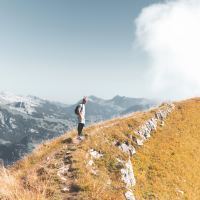 Man hiking on a mountain on a cloudy day.